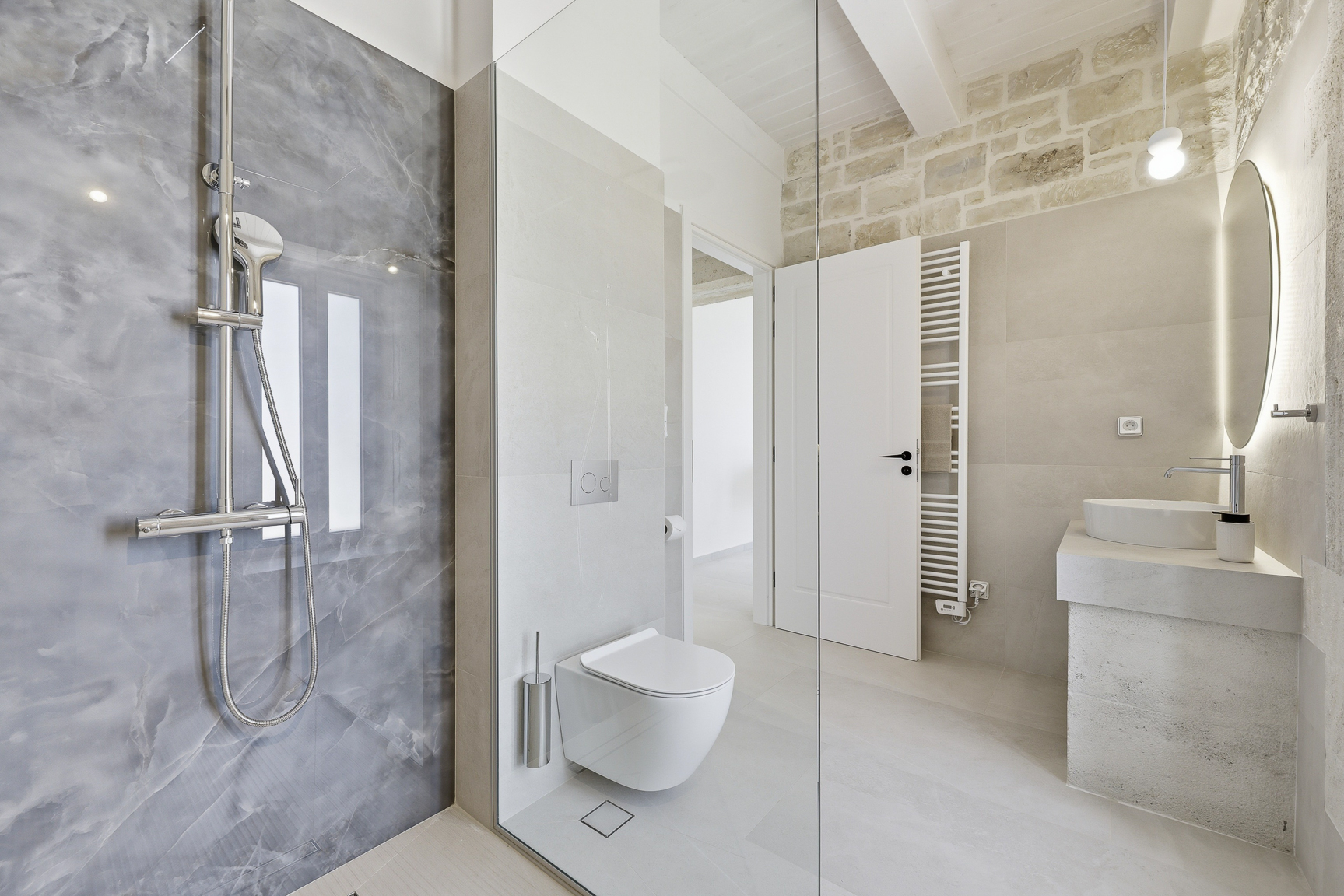 Helles Badezimmer mit bodengleicher Dusche und Steinwaschtisch