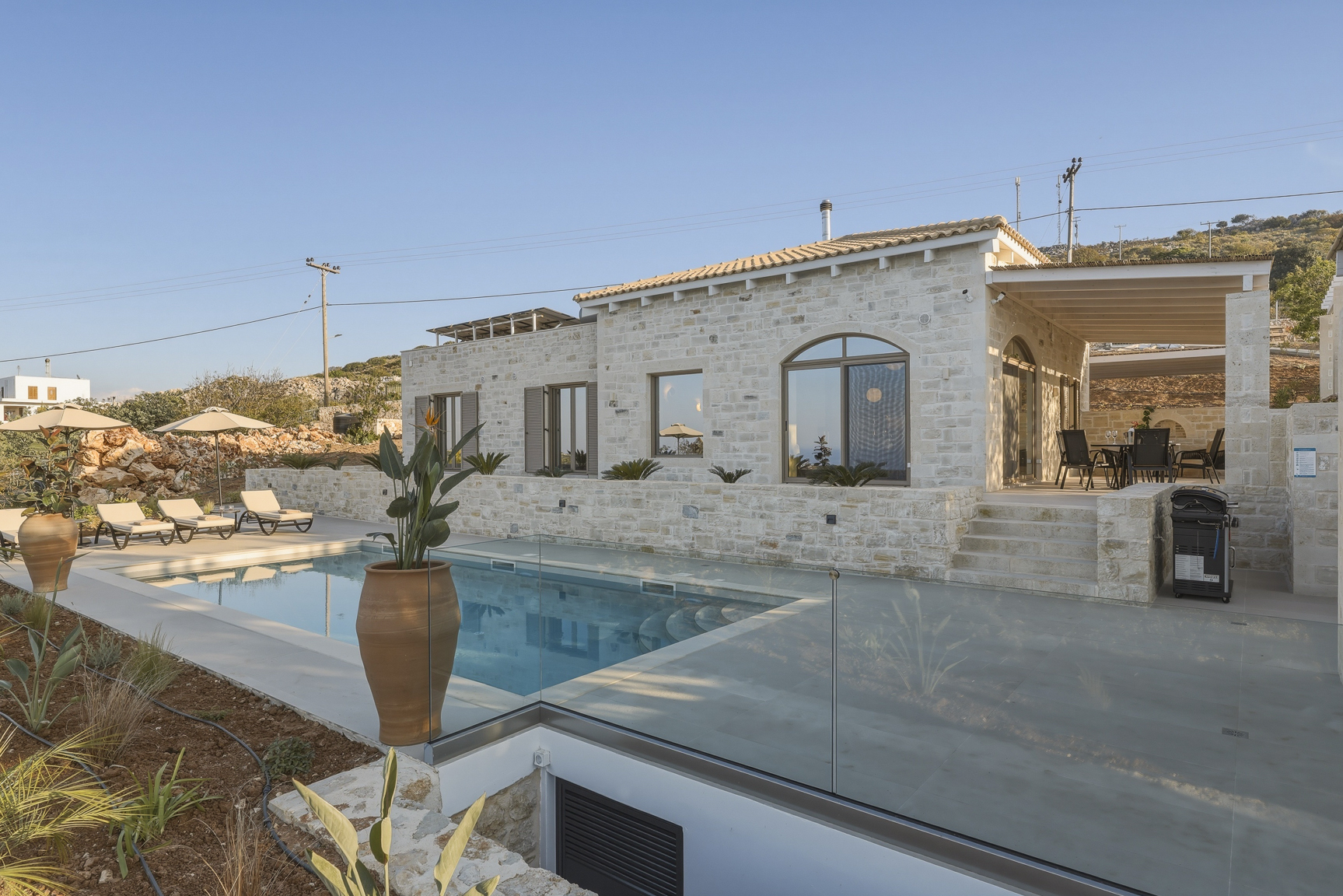 Außenansicht der Villa mit Poolterrasse im warmen Abendlicht